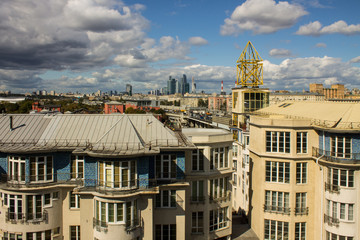 Fototapeta na wymiar panoramic view on top of the roof of the building in the foreground and sights in the distance on the background of blue cloudy sky in Moscow Russia