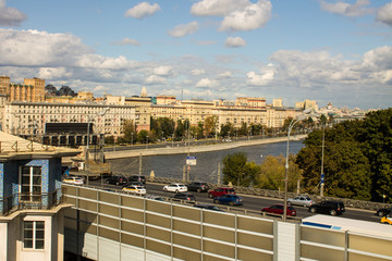 Naklejka premium a view of the Moskva river and the embankment with historic buildings in the city centre a cloud on a summer day