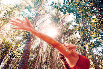 Peace and healthy concept.Woman with open arms in nature landscape.Sunlight and trees