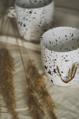 Obraz premium Two white cups on a linen tablecloth. Rustic background