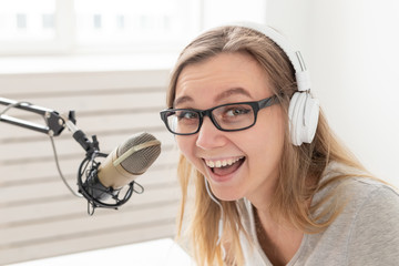 Radio, blogging, podcasting concept - close-up of young woman working as a dj on the radio.