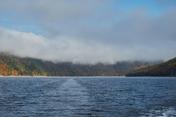 Autumn lake in Norway covered with fog among the mountains and forests