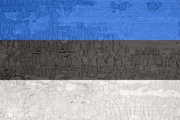 Estonia flag on an old painted tattered wooden surface.