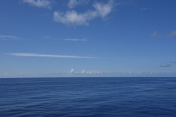 Obraz premium Calm ocean and a blue sky on a sunny day.