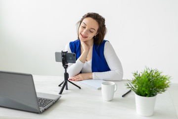Blogging and vlog concept - young woman blogger talking on the camera