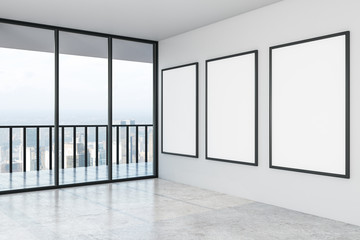 Blank three white mock up posters on white wall in modern empty spacious hall with city view.