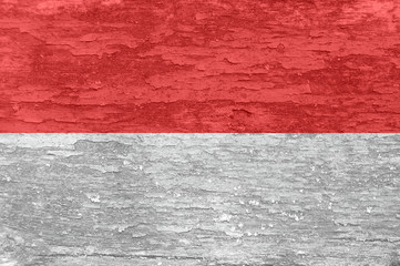 Monaco flag on an old painted wooden surface.