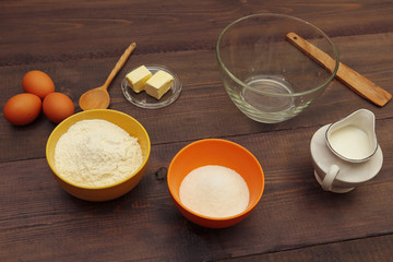 Ingredients for making dough on a wooden table.