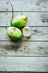 Fresh coconut juice in the jar and ripe coconuts on the vintage wooden table. - 290077403