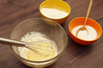Beating dough for baking on a rustic wooden table.