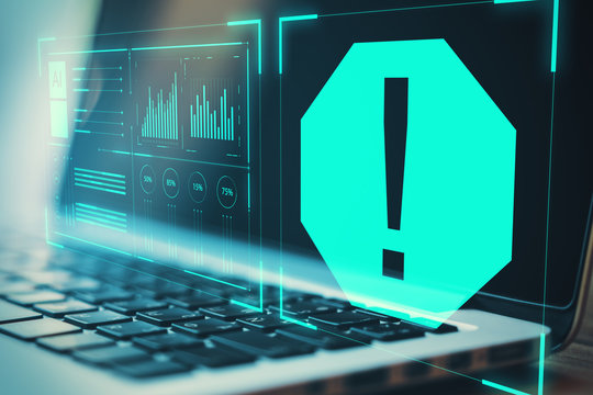 Warning system concept with digital exclamation point at blurry laptop background.