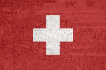 Switzerland flag on an old painted tattered wooden surface.