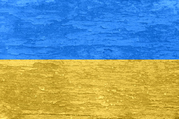 Ukraine flag on an old painted wooden surface.