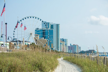 Beach, hotel, and ferris wheel and boardwalk in Myrtle Beach, South Carolina.