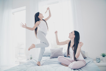 Fototapeta na wymiar Portrait of two nice beautiful attractive charming lovely funny funky careless carefree playful cheerful cheery people having fun on linen sheets singing pop hit in light white interior room indoors