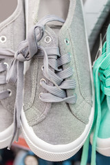 Sports shoes in neutral color, gray sneaker. Lacing on boots, vertical