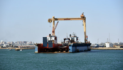 Fototapeta premium Dry dock near the Suez city in Egypt, view from the cargo ship transiting Suez Canal. 