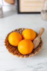 oranges and hand citrus squeezer on a marble background with copy space