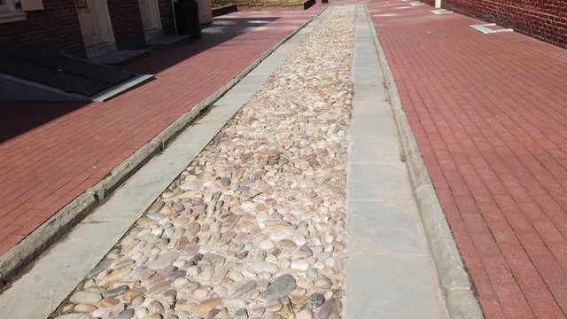 Moving along a colonial path with cobblestone in the center, concrete edges and bordered by brick