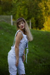 portrait of a young woman in overalls with long hair