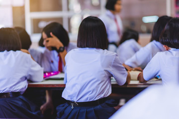 The Asian high school students in white uniform are studying in the classroom,.