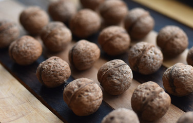 walnuts lie in straight rows on a striped background