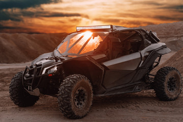 Buggy parked in the desert during sunset at