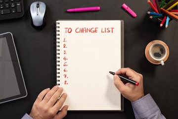 Writing To Change List, Over Head View Of Work Desk.