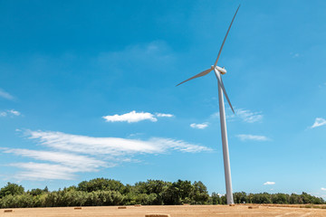 single wind turbine on a blue summer sky