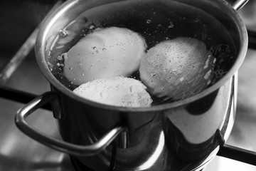 Fototapeta na wymiar Cooking boiled eggs in pan on stove 