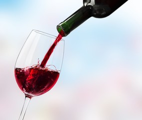 Red wine glass and bootle on wooden table