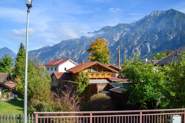 Roofs of beautiful houses in a village in the Alps in autumn with mountains in the background