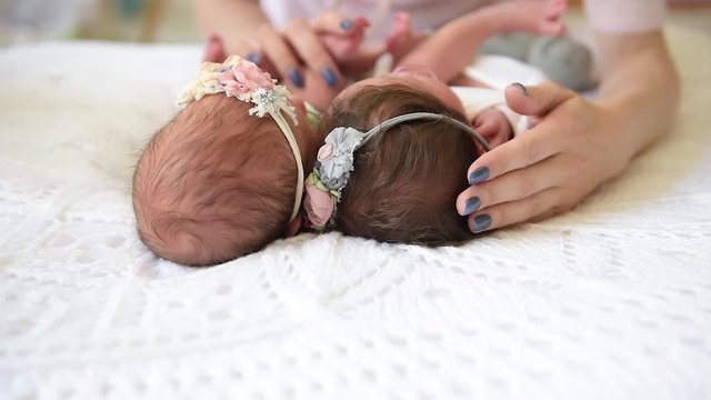 Newborn twins sisters and gentle mother&rsquo;s hands during the pumping process