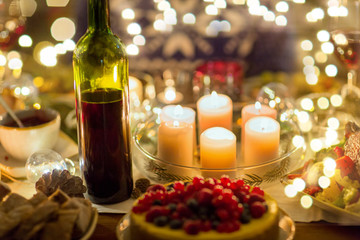 christmas dinner and decoration concept - food, drinks and candles burning on table