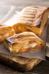 Traditional homemade apple strudel on wooden table
