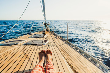 Close up of tourist woman caucasian feet lay down and relaxing enjoying a sail boat trip with ocean...