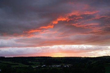 Fototapeta premium Dramatic Sunset Over a Farm Meadow