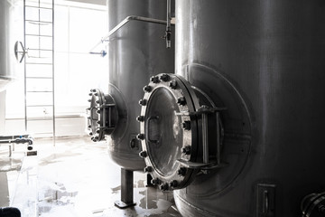 Iron or steel tank or cistern or reservoir for beverage with hatch in factory interior