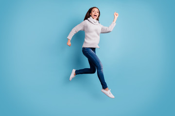 Fototapeta na wymiar Bargain. One minute - i am here. Full body photo of cute content teen youth jump run feel excited scream wear white knitted pullover sweater denim jeans sneakers isolated over blue color background