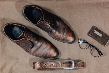 Brown leather retro shoes with strap glasses and a pocket watch. Vintage style.
