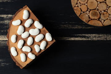 Beans - white raw dry legumes seeds on wooden background, space for copy