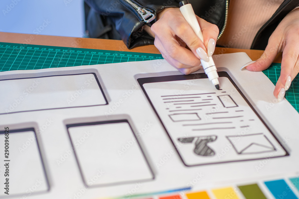 Poster the designer draws a freehand diagram of the user interface. mobile app designer at work. the girl a