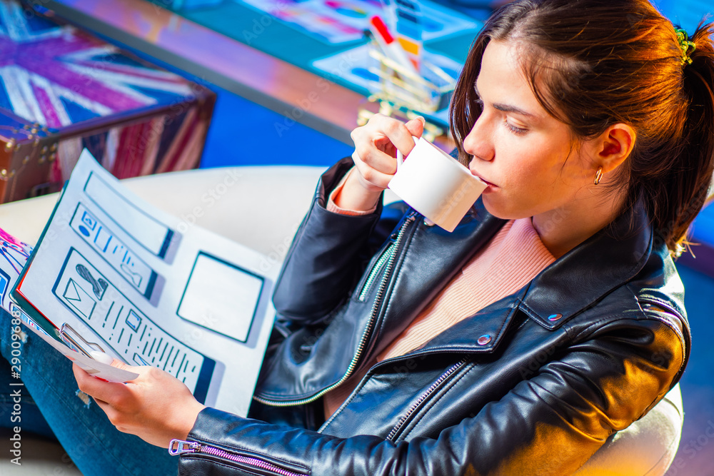 Poster mobile app designer reflects on his project over a cup of coffee. development of the user interface 