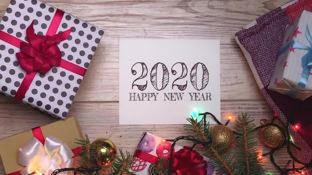 White sheet with text. 2020. Presents for the family. Beautiful presents under the Christmas tree. New Year interior. Happy holidays. New Year's gift box. Holidays and celebrations concept