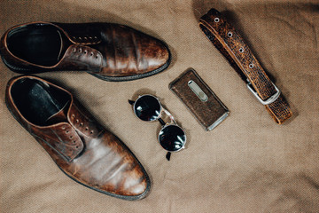 Brown leather retro shoes, belt, steampunk sunglasses and a pocket watch. Vintage style.