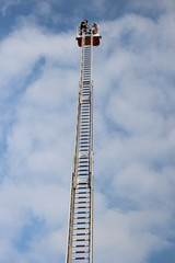 fire department ladder high in the sky with clouds