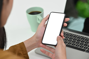 Young female holding mobile phone with empty screen isolated and clipping path.