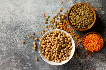 Healthy food, dieting, concept vegan protein source. Raw of legumes (chickpeas, red lentils, canadian lentils). Top view flat lay. Free space for your text.