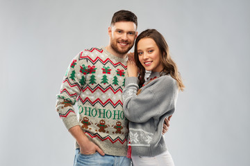 christmas, people and holidays concept - portrait of happy couple at ugly sweater party