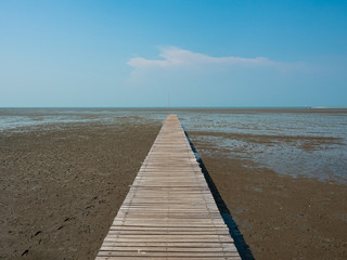 Fototapeta na wymiar Perspective long wooden bridge extending into the sea